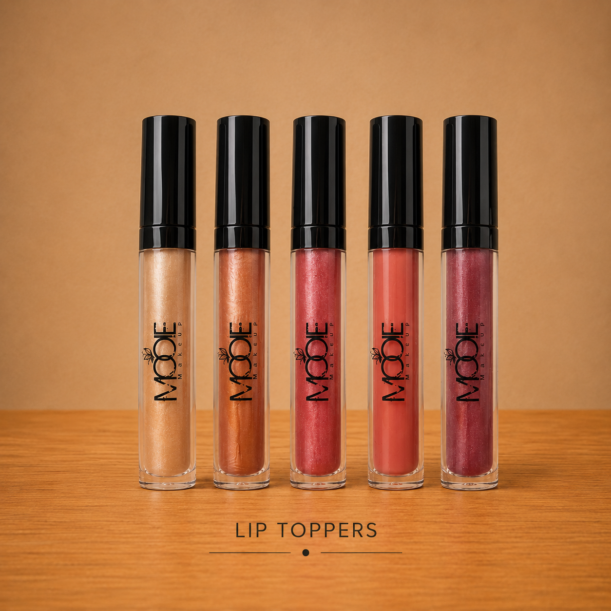 Five lip topper gloss tubes on wooden surface