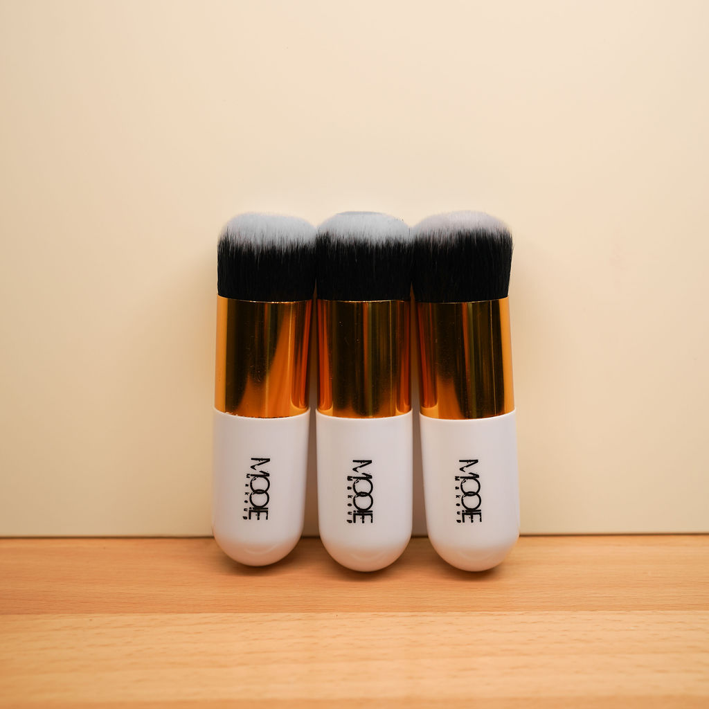 Three makeup brushes with golden handles